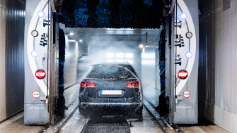 Bilden visar en bil inne i en automatiserad biltvätt