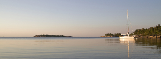 Bilden visar en segelbåt i skärgårdsmiljö