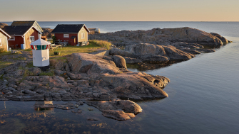 Bilden visar stugor på ett skär i skärgården. 