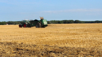 Bilden visar ett fält med en jordbruksmaskin