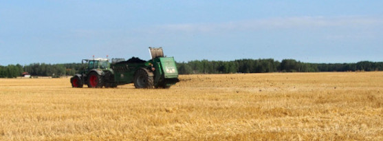 Bilden visar ett fält med en jordbruksmaskin. Varje år återför vi cirka 30 000 ton avvattnat slam till kretsloppet